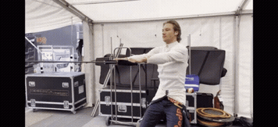 A Man In A White Shirt Is Standing In Front Of A Sign That Says 150 On It GIF