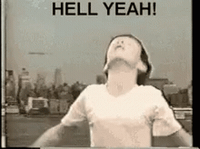 A Man In A White Shirt Is Standing In Front Of A Sign That Says Hell Yeah . GIF