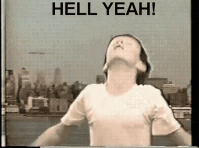 A Man In A White Shirt Is Standing In Front Of A Sign That Says Hell Yeah ! GIF