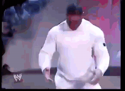 A Man In A White Shirt Is Standing In Front Of A Sign That Says W On It GIF