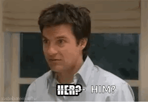 A Man In A White Shirt Is Standing In Front Of A Window And Asking , `` Here ? Him ? '' GIF