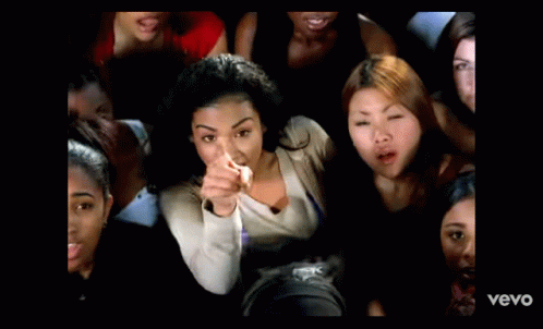 A Man In A White Shirt Is Standing In Front Of A Window With The Word Vevo On The Bottom Of The Screen GIF