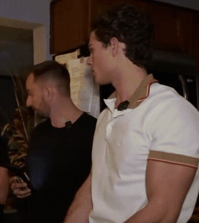 A Man In A White Shirt Is Standing Next To A Man In A Black Shirt GIF