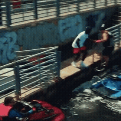 A Man In A White Shirt Is Standing On A Dock Next To A Jet Ski GIF