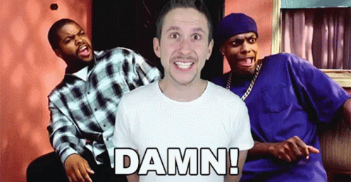 A Man In A White Shirt Is Surrounded By Two Men And The Word Damn Is On The Front Of His Shirt GIF