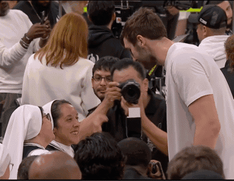 A Man In A White Shirt Is Taking A Picture Of A Woman GIF