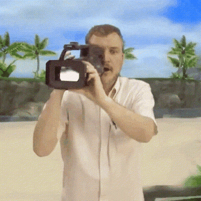 A Man In A White Shirt Is Taking A Picture With A Video Camera GIF
