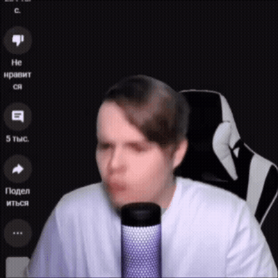 A Man In A White Shirt Is Talking Into A Microphone . GIF