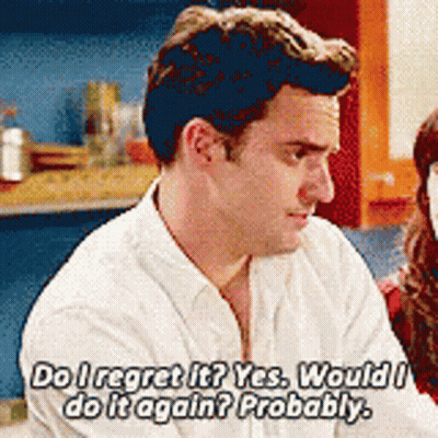 A Man In A White Shirt Is Talking To A Woman In A Kitchen . GIF