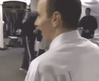 A Man In A White Shirt Is Talking To Another Man GIF