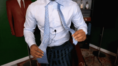 A Man In A White Shirt Is Tying A Tie GIF