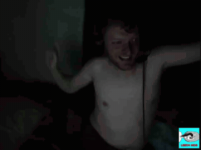 A Man In A White Shirt Is Waving His Hand In The Dark With The Words Peak Male Form Below Him GIF