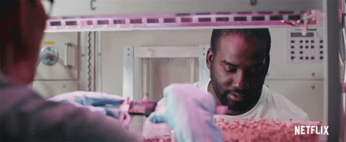 A Man In A White Shirt Is Working In A Room With Netflix Written On The Bottom GIF