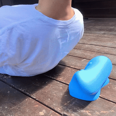 A Man In A White Shirt Sits On A Wooden Deck Next To A Blue Object GIF