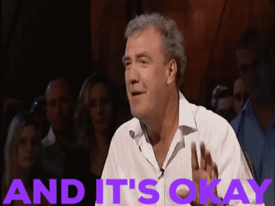 A Man In A White Shirt Stands In Front Of A Crowd With The Words And It 'S Okay Behind Him GIF