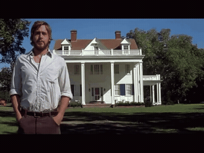 A Man In A White Shirt Stands In Front Of A Large White House GIF