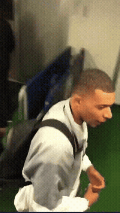 A Man In A White Shirt With A Black Backpack GIF