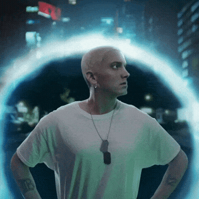 A Man In A White Shirt With A Dog Tag Around His Neck Is Standing In Front Of A Portal GIF