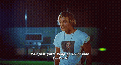 A Man In A White Shirt With A Picture Of A Man On It Says You Just Gotta Keep On Livin ' GIF