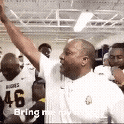 A Man In A White Shirt With The Number 46 On It Is Raising His Arms In The Air GIF