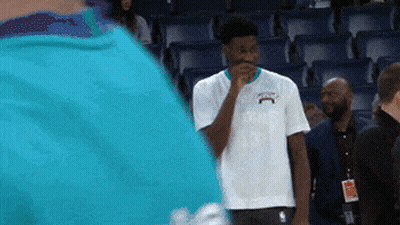 A Man In A White Shirt With The Word Charlotte On It Is Standing In A Stadium GIF
