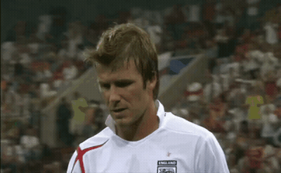 A Man In A White Soccer Jersey Is Standing On A Soccer Field In Front Of A Crowd . GIF