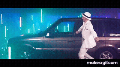A Man In A White Suit And Hat Is Dancing In Front Of A Car GIF