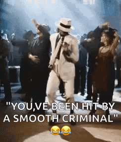 A Man In A White Suit And Hat Is Dancing With A Group Of People . GIF