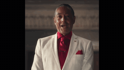 A Man In A White Suit And Red Tie Is Standing In A Room . GIF