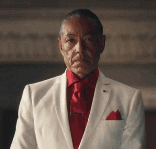 A Man In A White Suit Has A Red Tie GIF