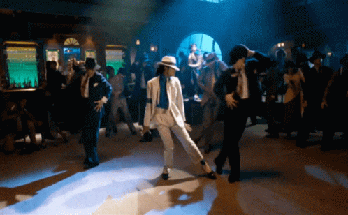 Man In White Suit Dancing In Dark Room GIF