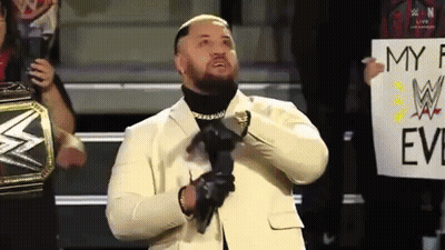 A Man In A White Suit Is Holding A Sign That Says My F W Evil GIF