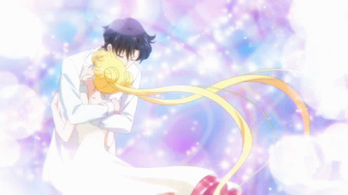 A Man In A White Suit Is Hugging A Woman In A White Dress With Her Hair Blowing In The Wind GIF