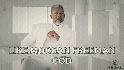 A Man In A White Suit Is Sitting At A Table With The Words Like Morgan Freeman God GIF