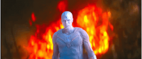 A Man In A White Suit Is Standing In Front Of A Red Fire . GIF