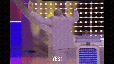 A Man In A White Suit Is Standing In Front Of A Wall With His Arms Outstretched And Says Yes . GIF