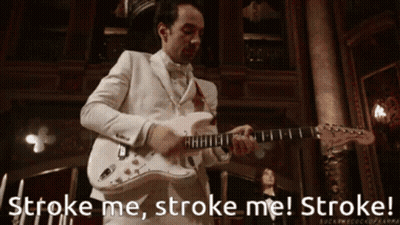 A Man In A White Suit Playing A Guitar With The Words Stroke Me Stroke Me Stroke GIF