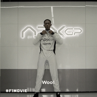A Man In A White Suit Stands In Front Of A Sign That Says Nxgp GIF