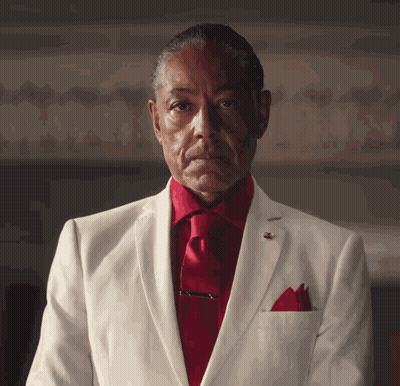 A Man In A White Suit With A Red Tie GIF