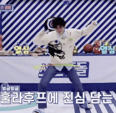 A Man In A White Sweater Is Dancing In Front Of A Sign That Says ' Basketball ' On It GIF
