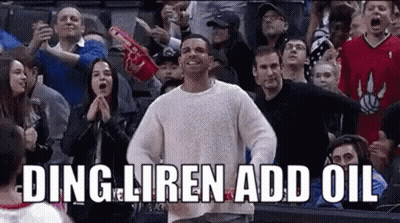 A Man In A White Sweater Is Standing In Front Of A Crowd . GIF