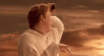 A Man In A White Sweater Is Standing In Front Of A Sunset With His Hands On His Head . GIF