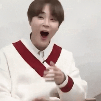 A Man In A White Sweater With A Red Stripe On The Sleeves Is Making A Funny Face With His Mouth Open . GIF