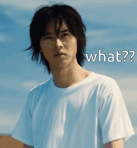 A Man In A White T-Shirt Has The Word What On His Face GIF