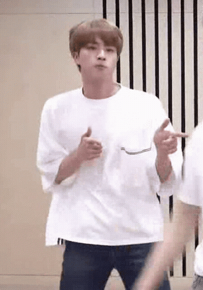 A Man In A White T-Shirt Is Dancing In A Room . GIF