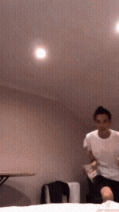 A Man In A White T-Shirt Is Jumping In The Air GIF