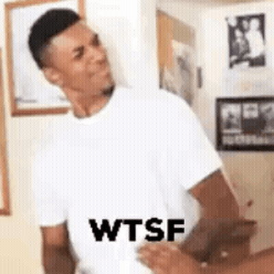 A Man In A White T-Shirt Is Standing Next To A Woman In A Room And Making A Funny Face . GIF