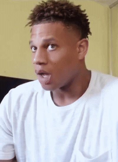 a man in a white t-shirt is sticking his tongue out