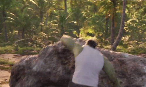 A Man In A White Tank Top Holds A Large Rock On His Shoulders GIF