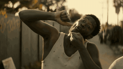 a man in a white tank top holds his hand to his face